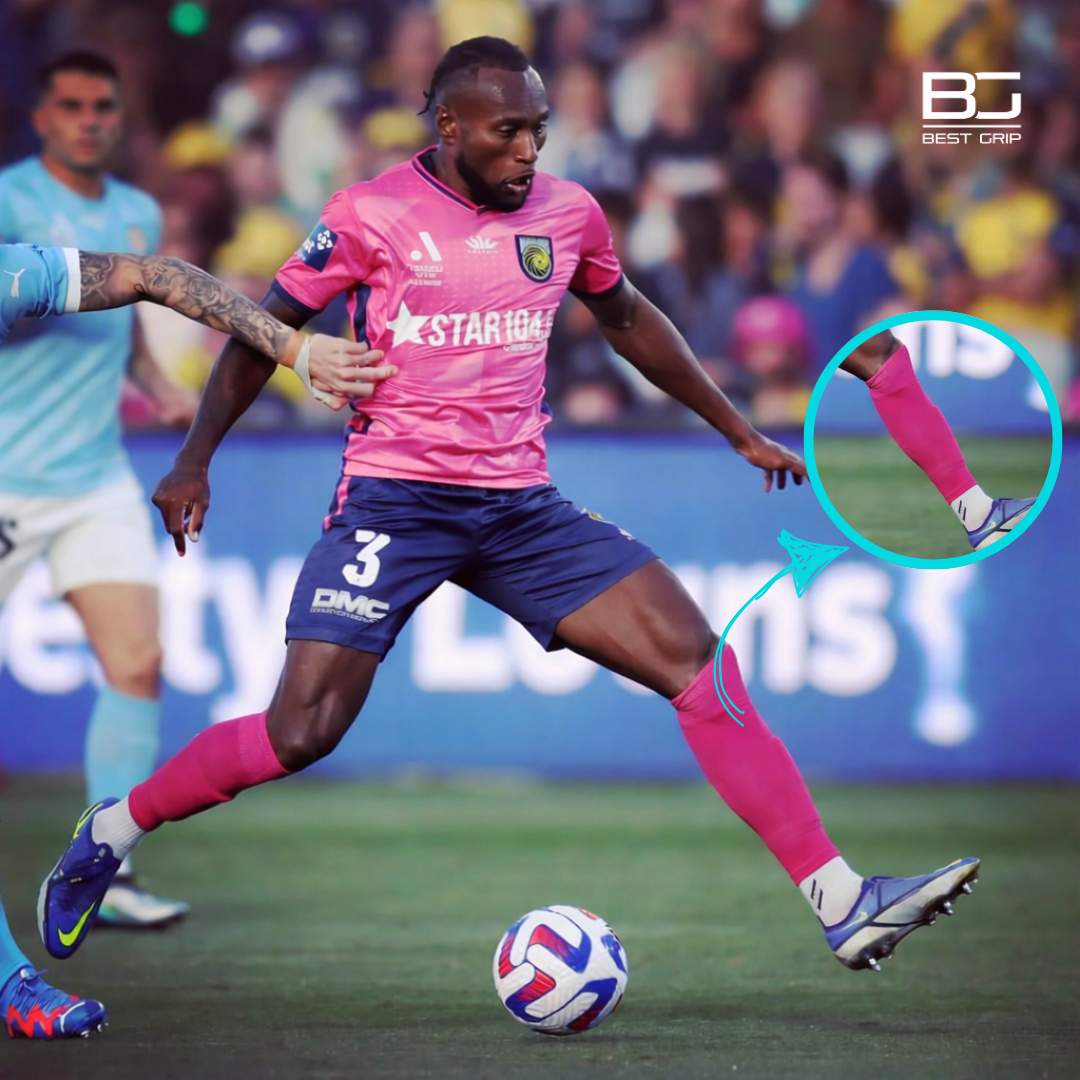 Football player wearing pink sock sleeves during match