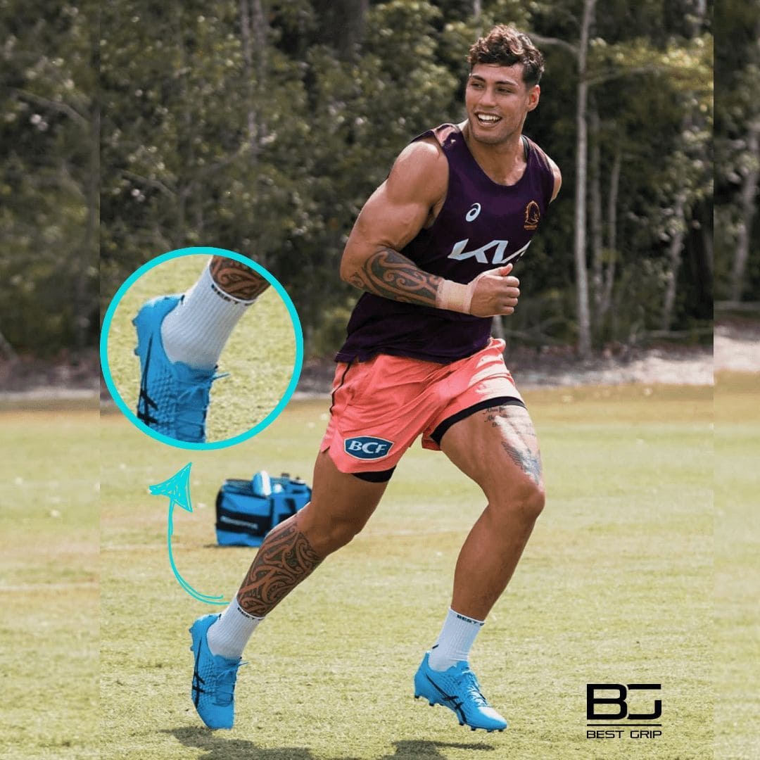 Kiwi pugby player playing in Australia running on a grass field with a focus on blue boots and socks