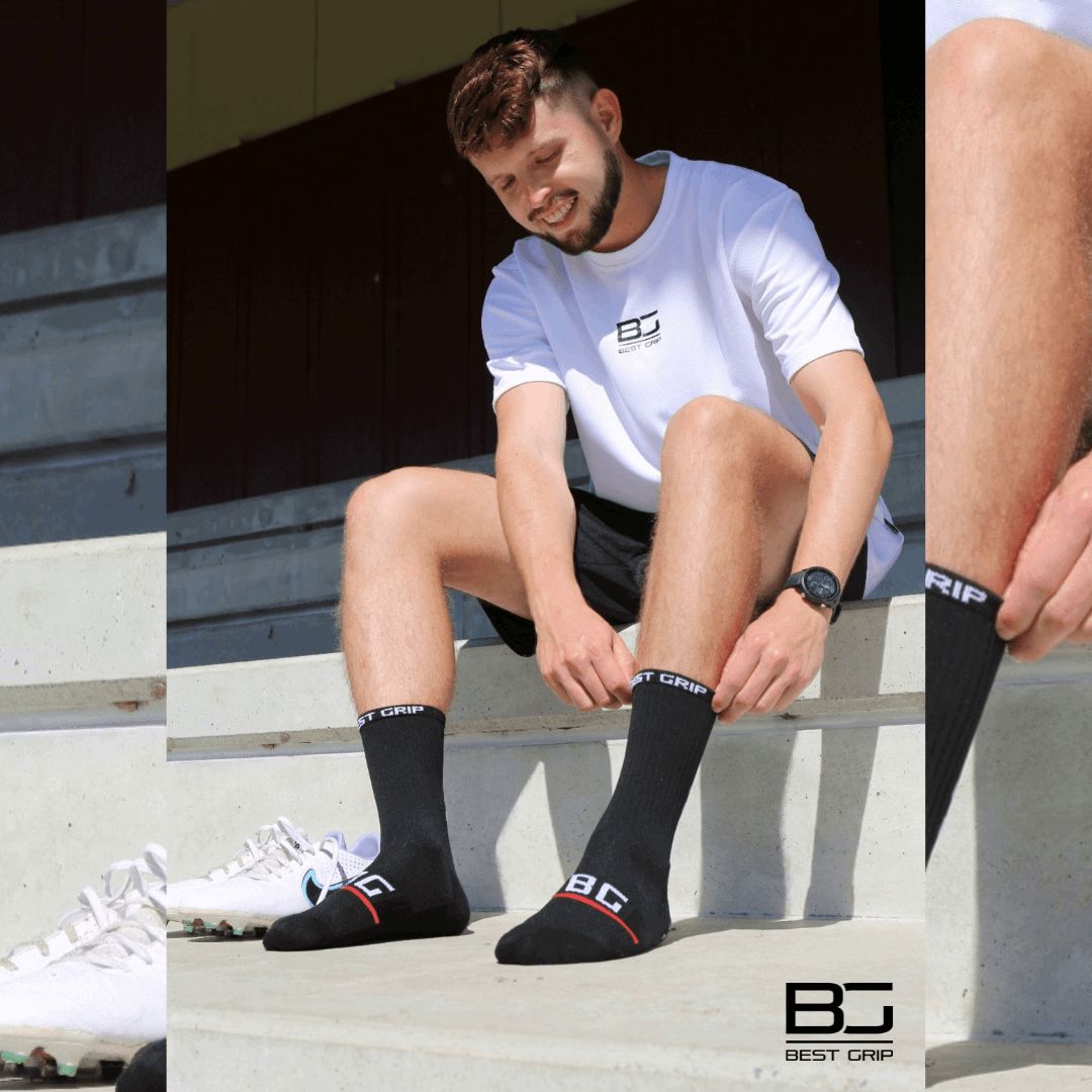 Player sitting on a bench wearing black socks with 'Best Grip' branding, surrounded by sports equipment.