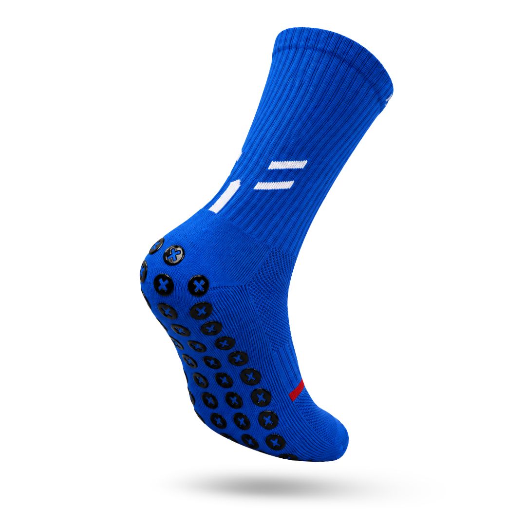 Royal Blue Best Grip Crew Performance Grip Sock Angled To Show Black XCORE Grip™ Pads With Blue X Centres Across The Sole, Ribbed Fabric, White Double Stripes And A Small Red Toe Accent Against A White Background.
