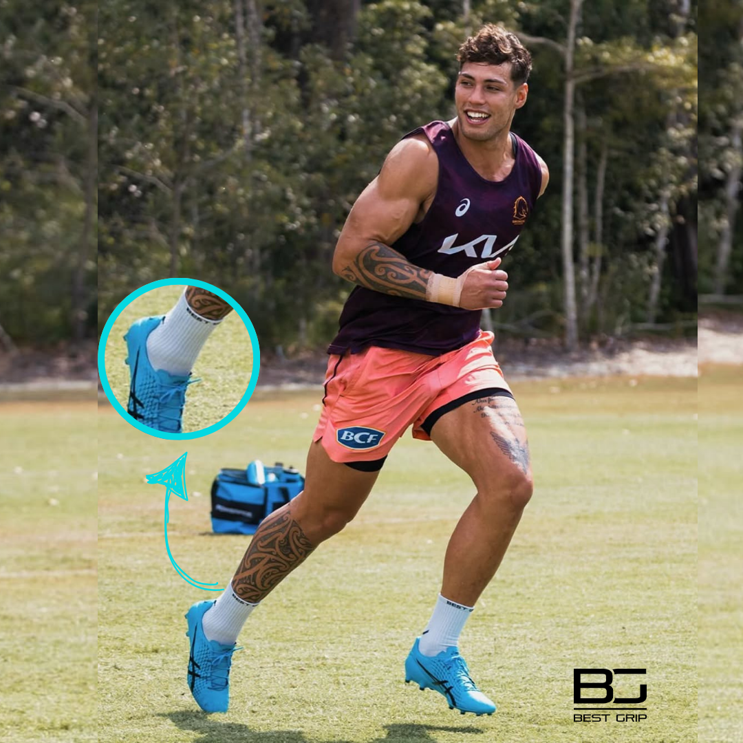 Kiwi pugby player playimg in Australia running on a grass field with a focus on blue boots and socks white grip socks